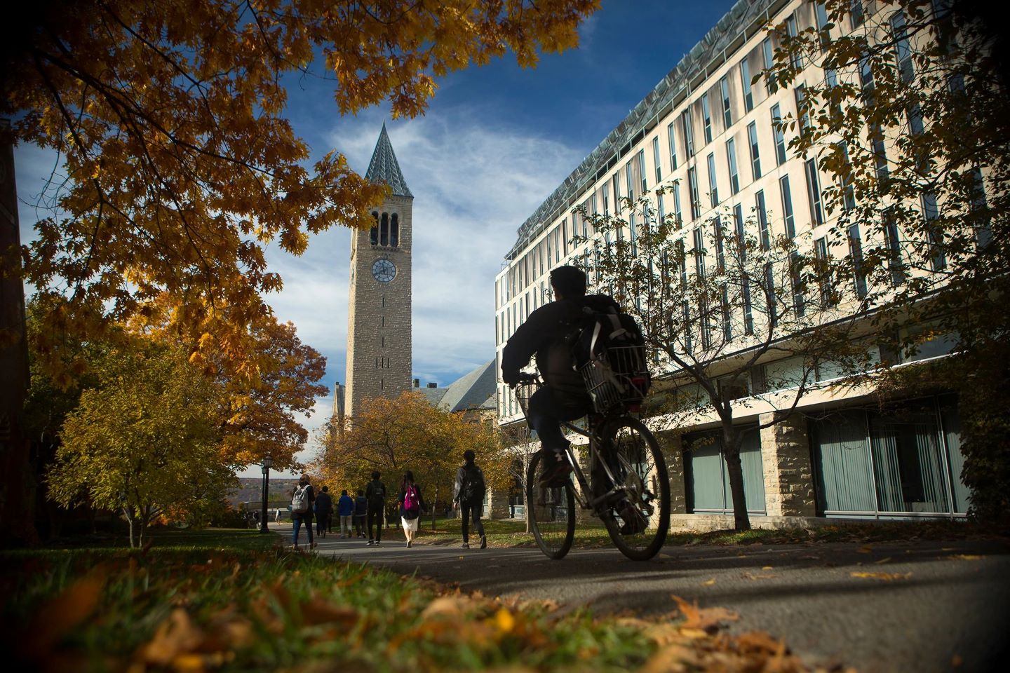 photo of person biking, McGraw tower in the background