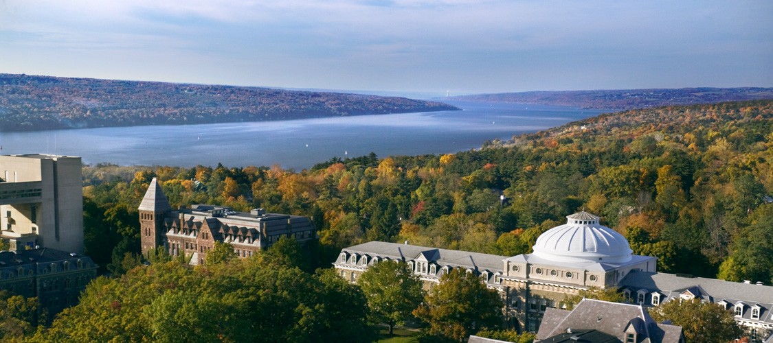 An aerial view of central campus in fall, with Cayuga Lake. L-R: Tjaden Hall, Sibley Hall, Lincoln Hall.