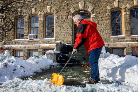 Staff person shoveling entryway in winter