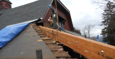 Image of Facilities Engineering working on the Big Red Barn's roof.